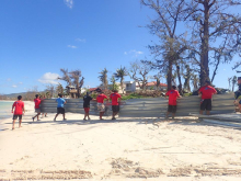 Community members remove tin panels off of a beach following a typhoon.