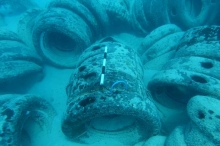 Numerous tires on the bottom of a sandy lagoon.