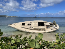 A derelict vessel beached near the shore.