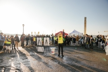 A group of volunteers are gathered to listen to a speaker using a megaphone.