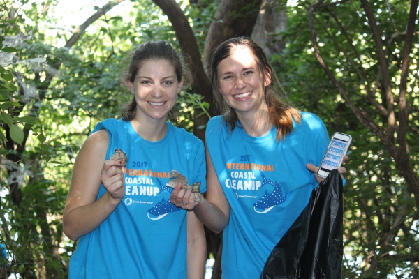 Two volunteers holding debris.